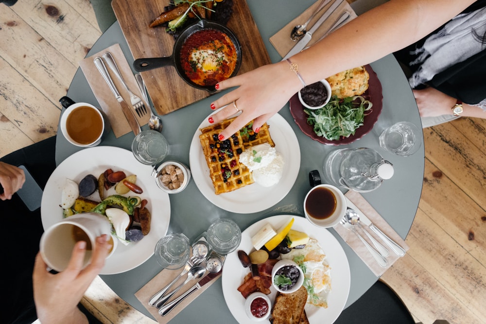 Gasten die gerechten met elkaar delen aan tafel